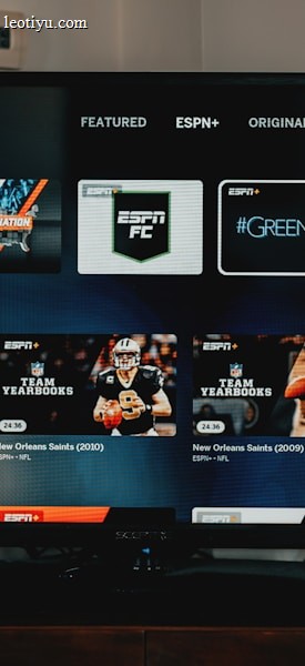A television screen displaying the ESPN+ streaming interface with various sports-related shows and categories. The screen includes sections such as 'Browse by Shows' and 'Best of Drew Brees' with thumbnails of sports programs featuring athletes in action and analysts.